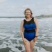Model wearing blue swim costume standing in sea