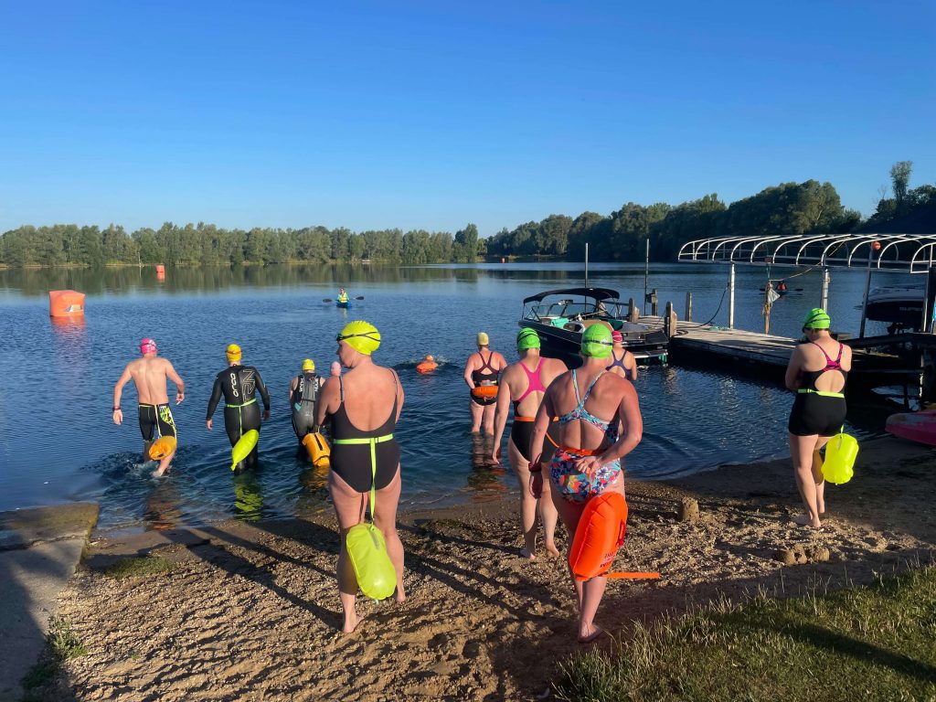 A group of swimmers entering a lake