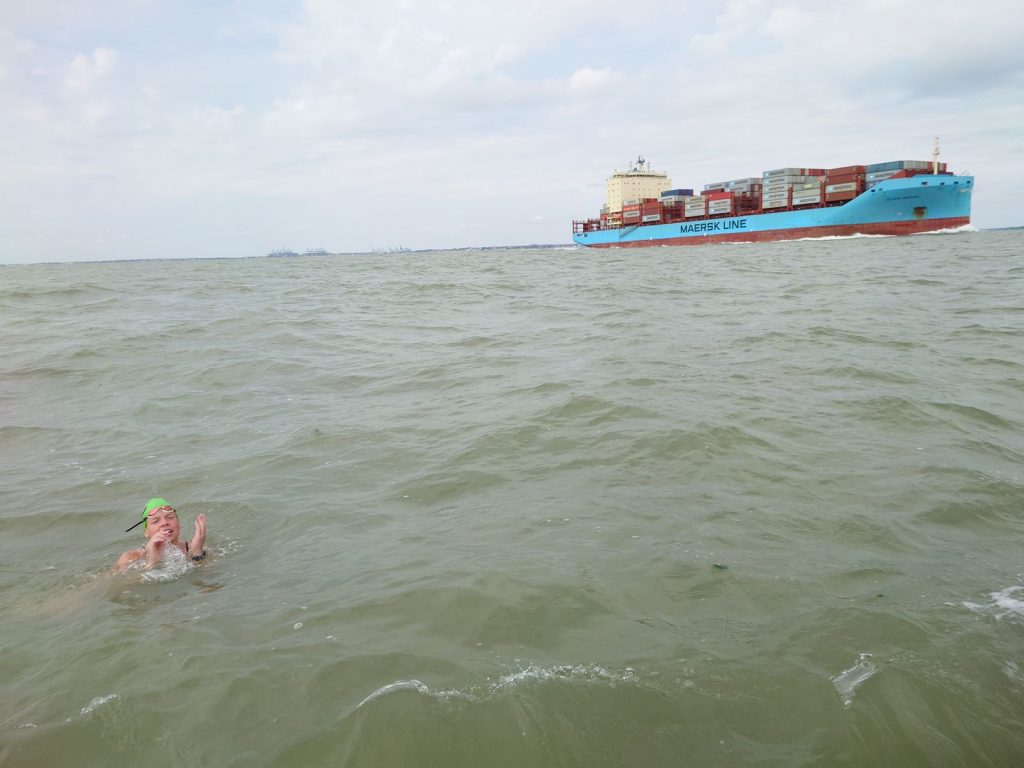 Swimming from Sealand for Aspire: The author in the water (foreground) waiting for a large container ship to pass