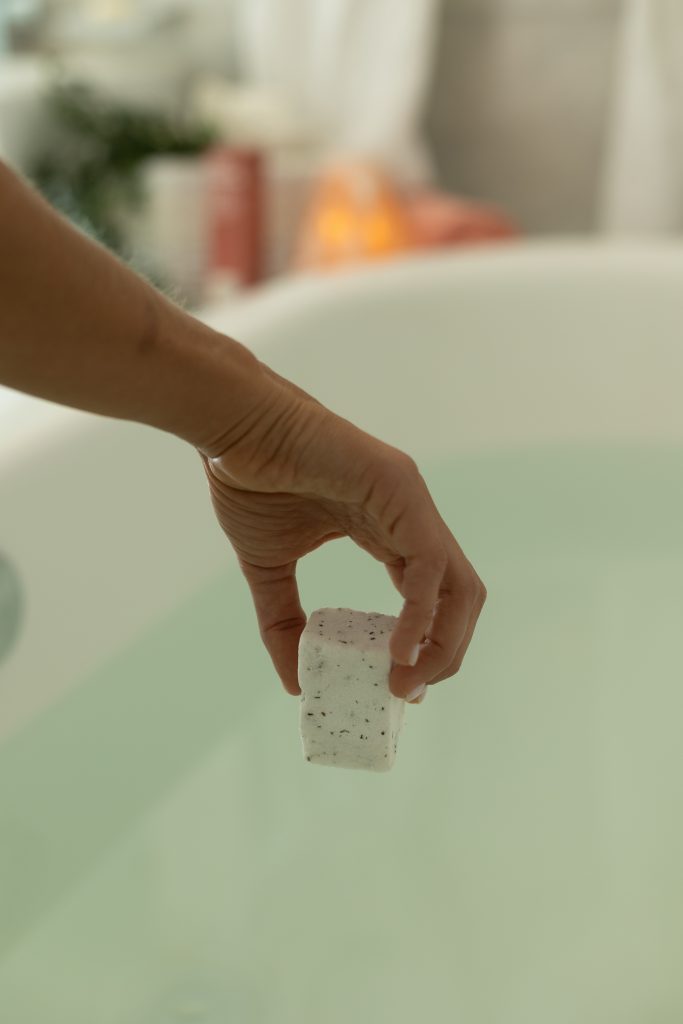 Hand dropping bath cube into bath