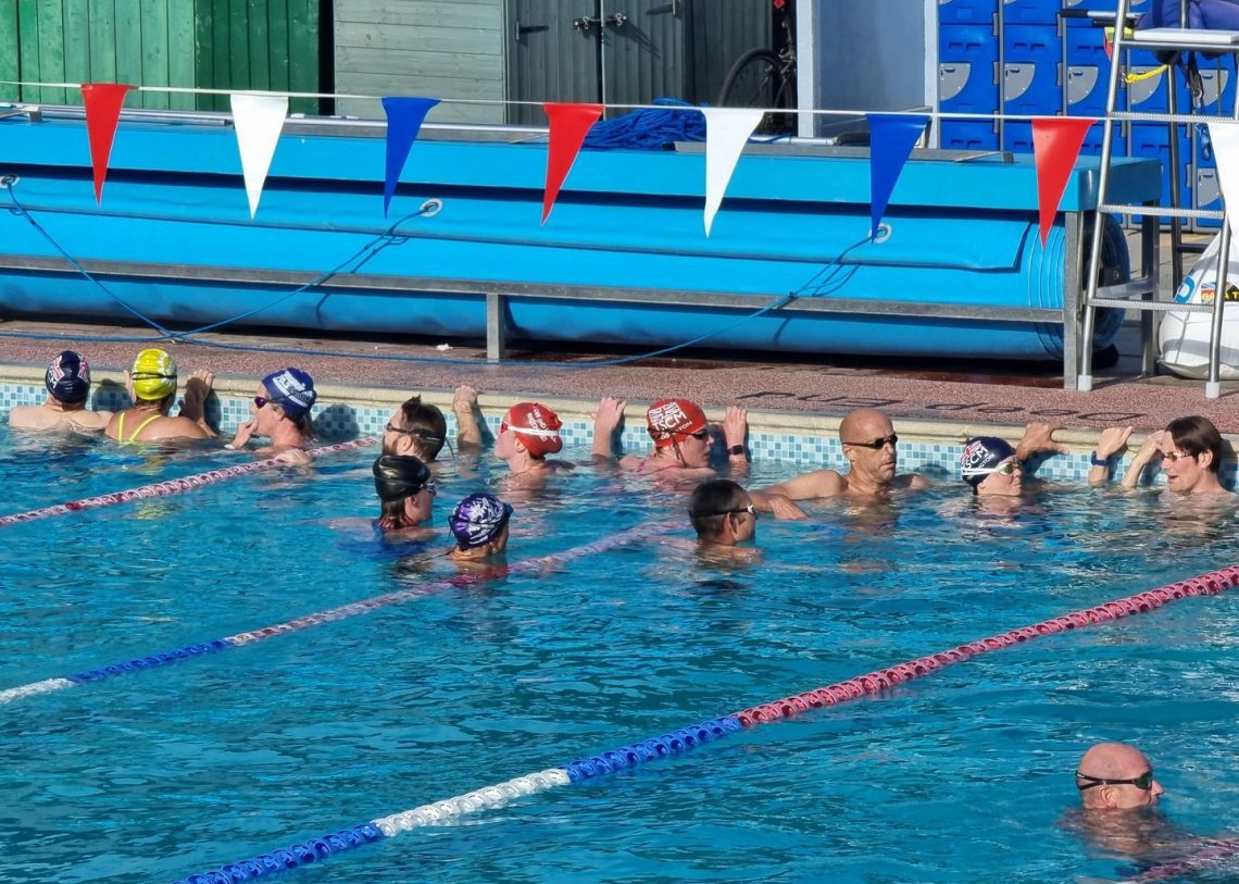 Swimmers waiting to swim, in an outdoor pool.
