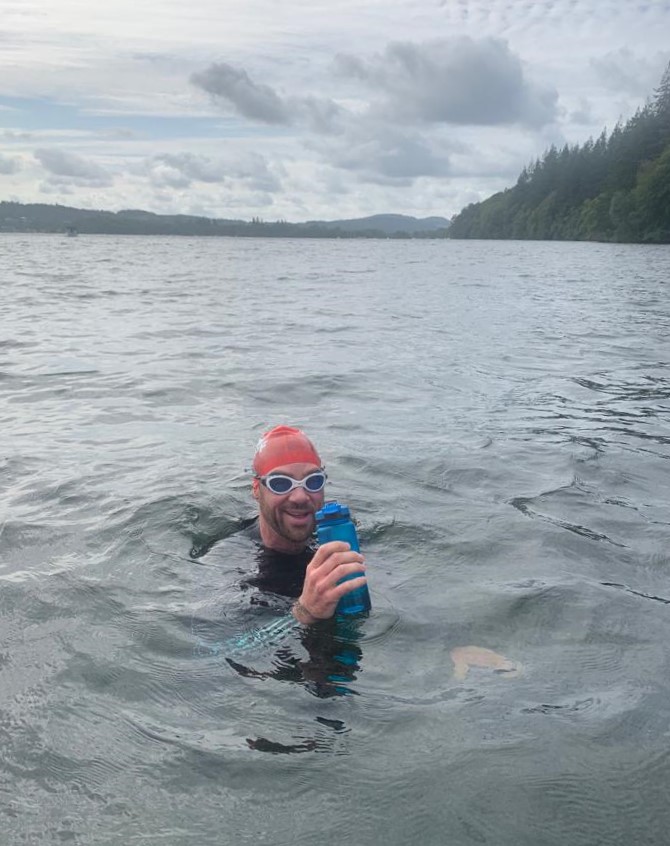 Matt Dawson drinking from a bottle in the middle of a lake