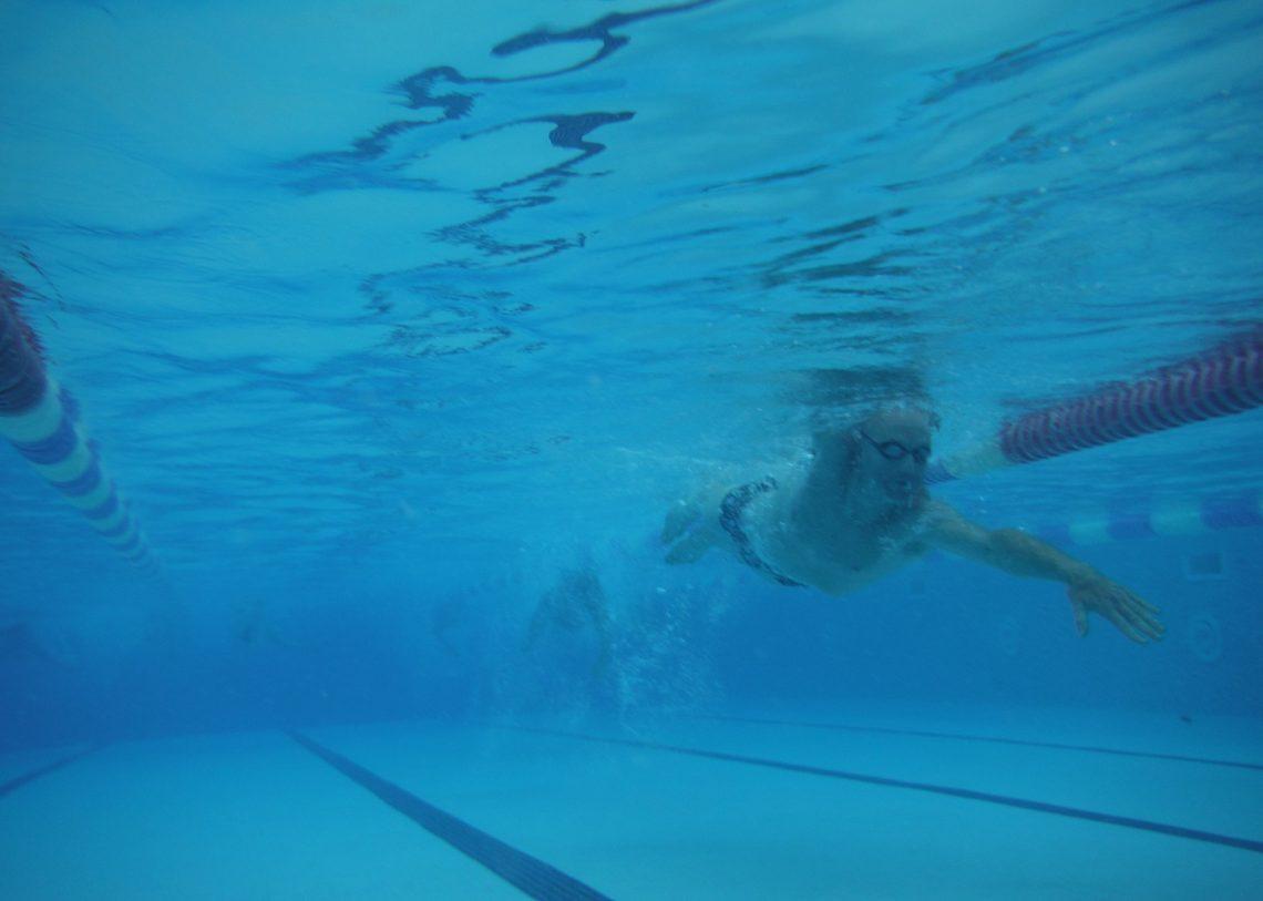 An underwater view of a male swimmer in a pool