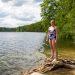 A woman in a swimming costume standing next to a lake