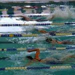 Swimmers racing in a pool, side view